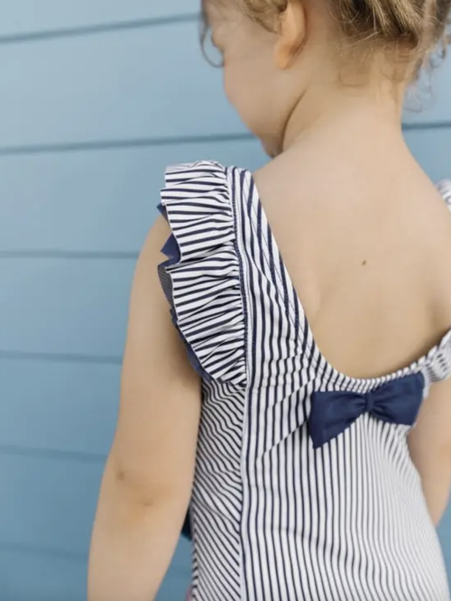 A favorite style in a nautical new navy stripe, it features waterfall detail for added flair. Made from a fabric with UPF 50+ sun protection built in, this girls' r