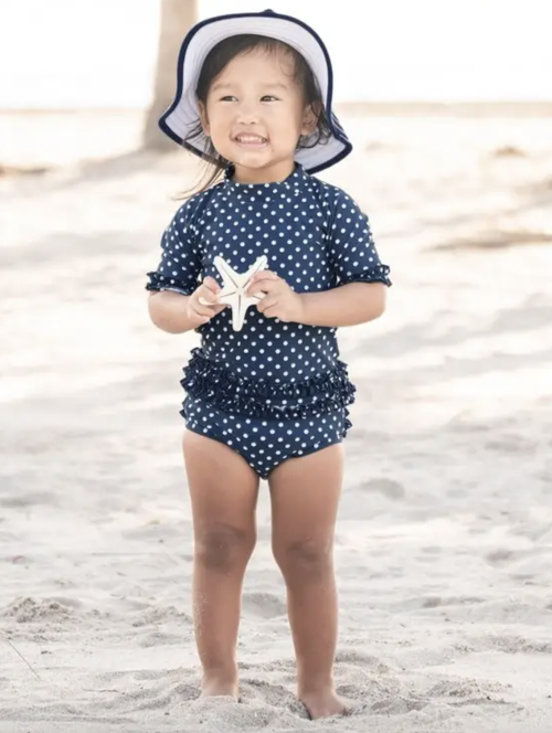 Add style to your little girl’s summer attire with this Navy Polka Dot Ruffled Bikini. This two-piece set is perfect for easy changing and offers sun protection w