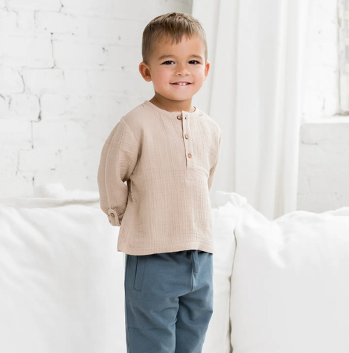Made with incredibly soft organic cotton muslin, this henley with adjustable sleeves and coconut buttons has a relaxed-fit silhouette that is a comfortable wardrobe