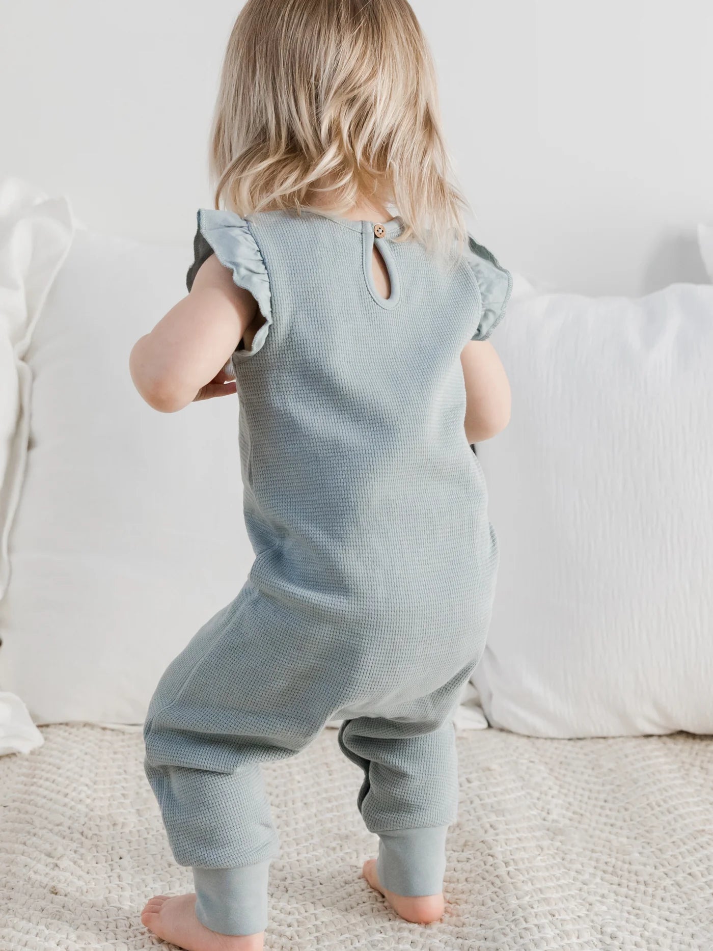 Our Maci Flutter Tank Romper is made from 100% organic waffled cotton, with eco-friendly coconut buttons and nickel-free snaps. The adorable flutter sleeve and neckl